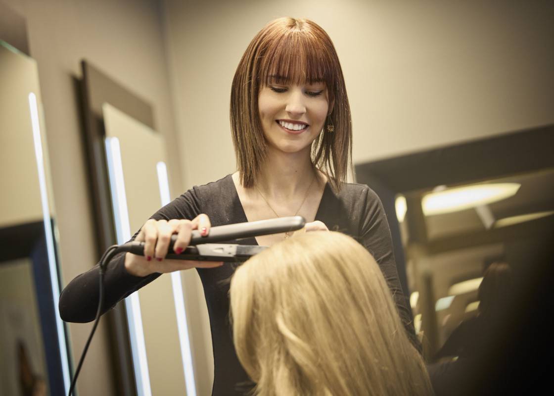 Friseurin frisiert Kundin die Haare