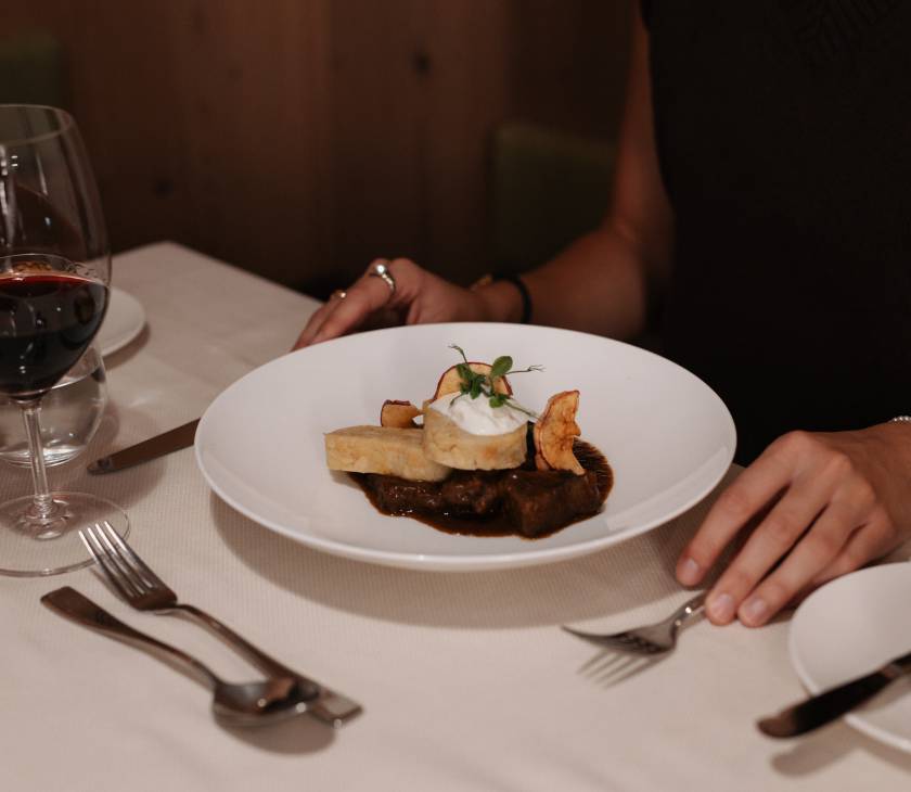 Frau isst Gulasch mit Semmelknödel