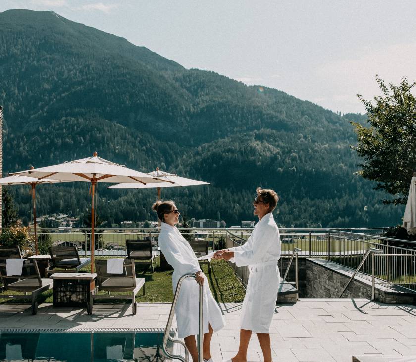 Paar steht im Außenbereich des Wellnesshotels Das Kronthaler