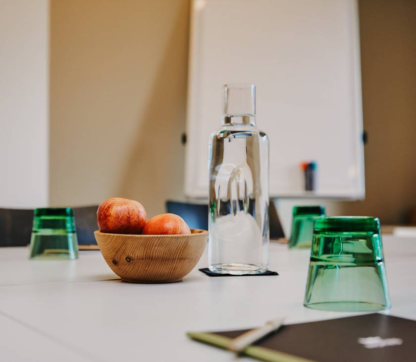 Äpfel und Wassergläser auf Tagungstischen