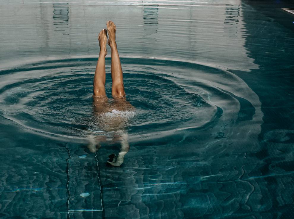 Frau taucht im Pool des Wellnesshotels Das Kronthaler